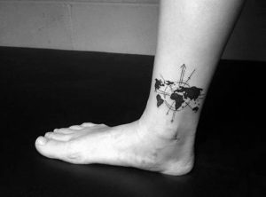 World Map Decorated With Circles And Arrows Tattooed In Black On A Man S Ankle Small Tattoos With Meaning Travel The World 300x222 